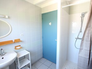 Bathroom features a white sink, toilet, and shower area with a glass door.