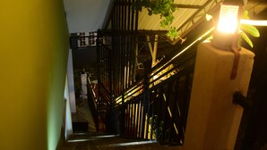 Una escalera con barandas de metal y una planta colgante.