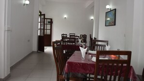 Un comedor con una mesa larga, sillas y un mantel rojo.