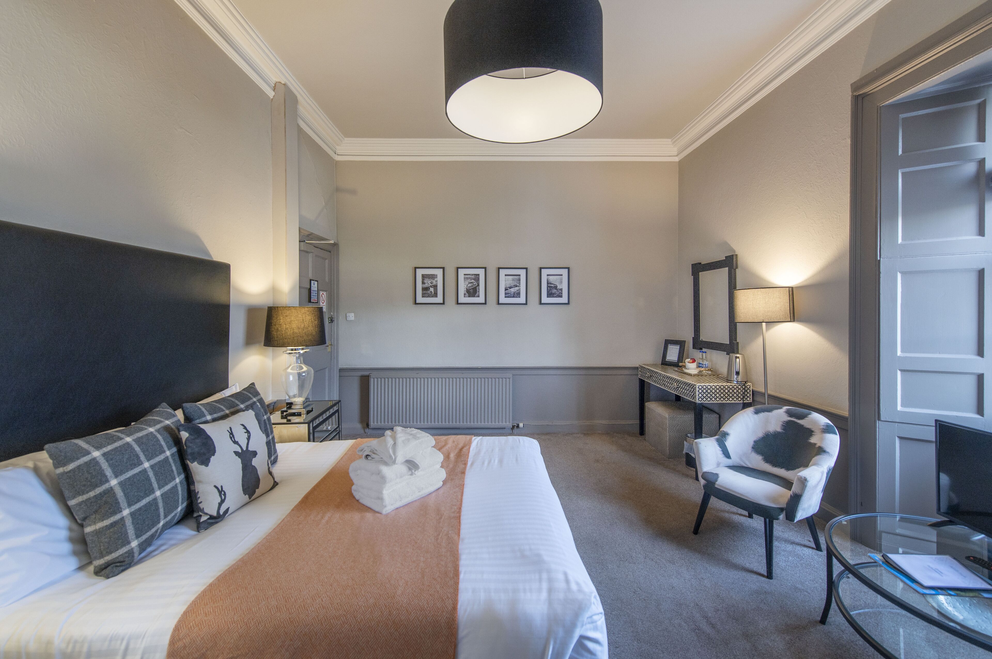 Una habitación de hotel con una cama, una silla, un escritorio y un televisor.