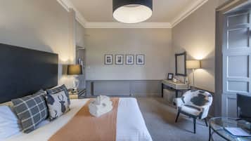 Una habitación de hotel con una cama, una silla, un escritorio y un televisor.