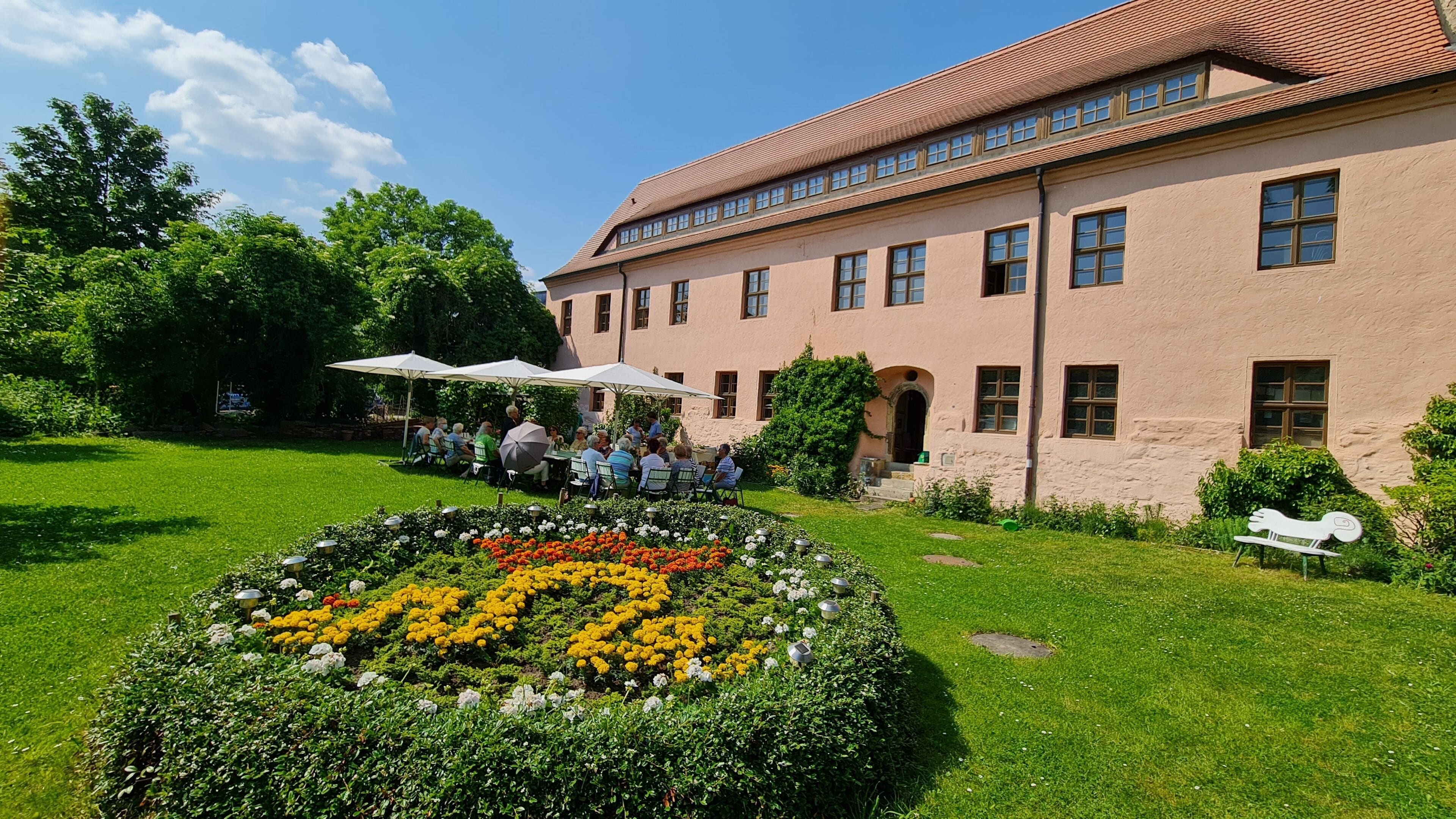 Ein Gebäude mit Gartenanlage, Außenbereich und einer Zierrabatte.
