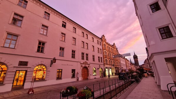 En historisk bygning med flere etager, store vinduer og en traditionel europæisk arkitektur.