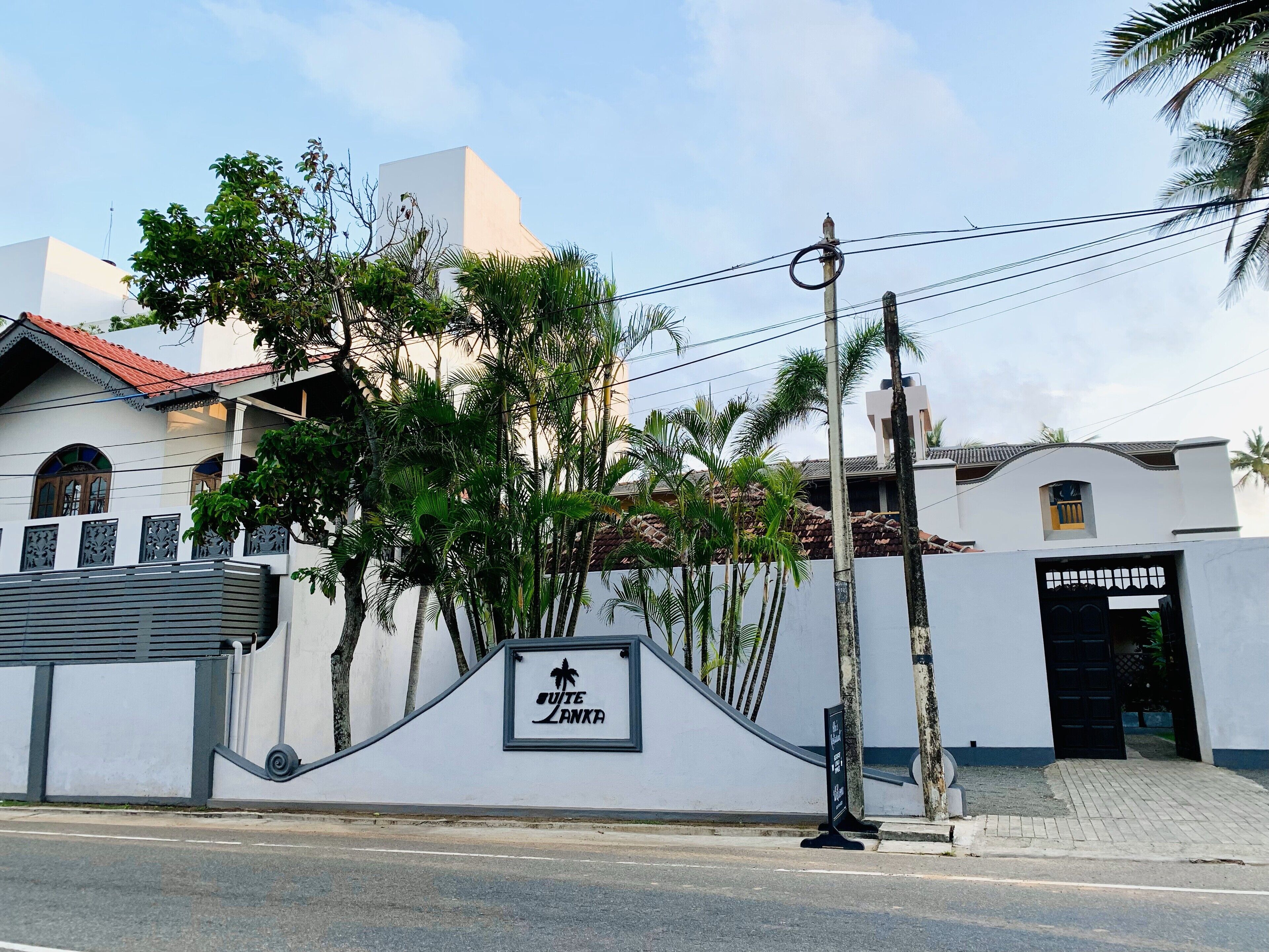 A building with a sign reading "Suite Lanka" and a palm tree in front.