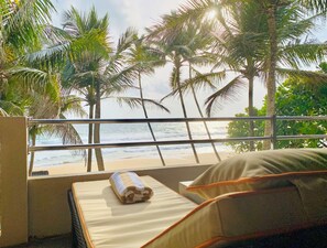 A balcony with a view of the beach and palm trees. - Suite Lanka (Hikkaduwa)