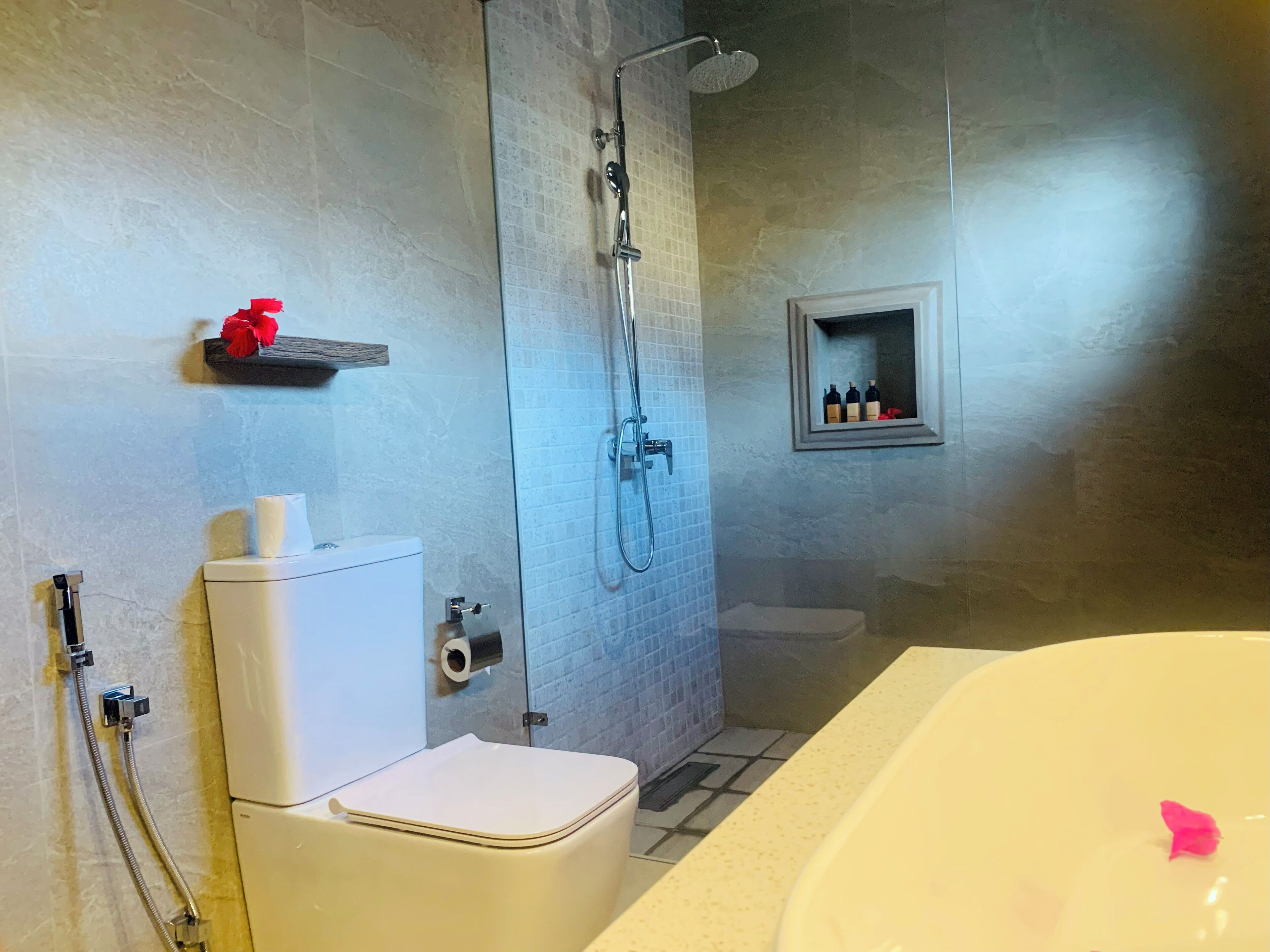Een badkamer met een toilet, douche en bad.