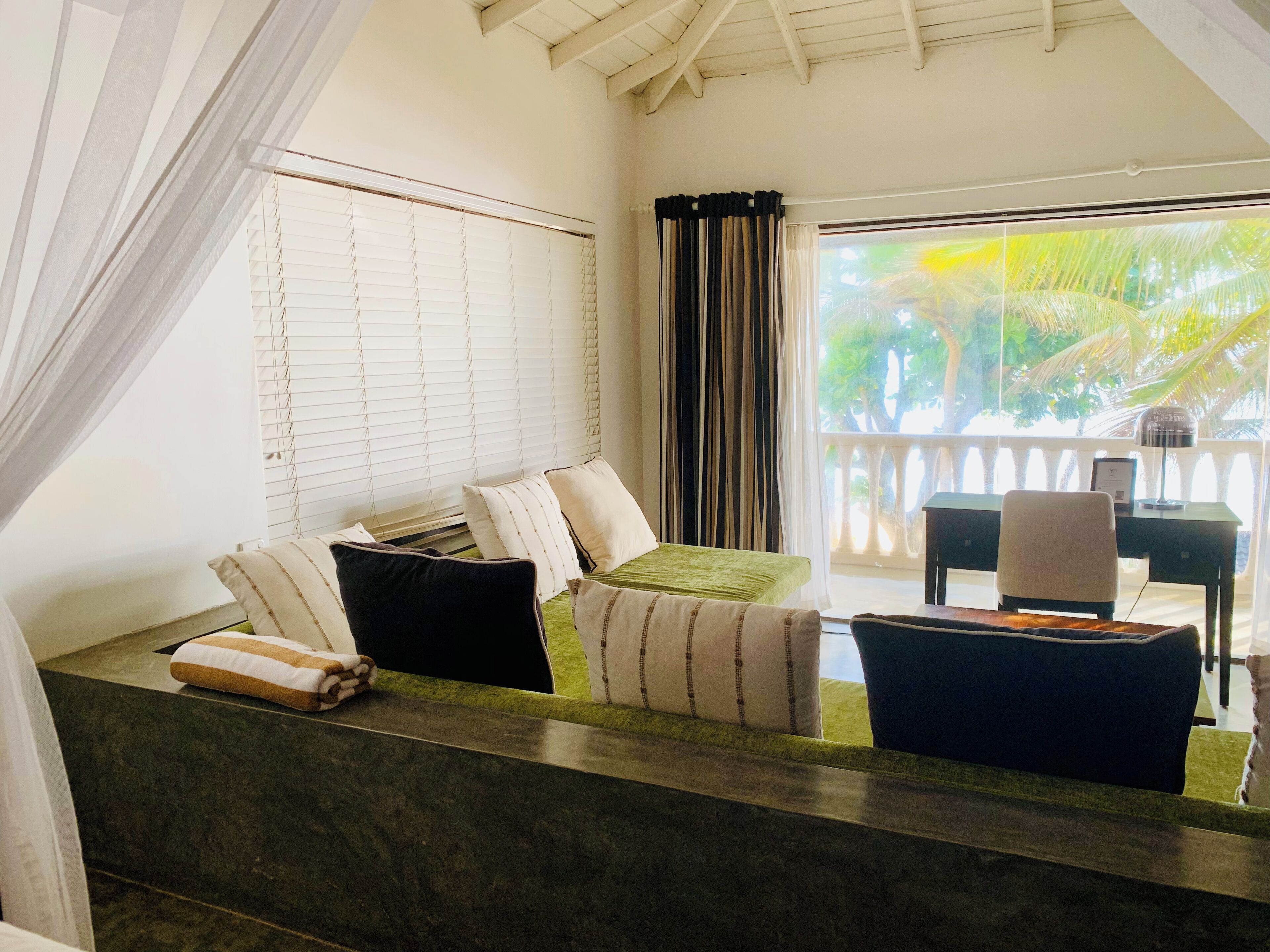 Una habitación con cama, escritorio y vista al exterior.
