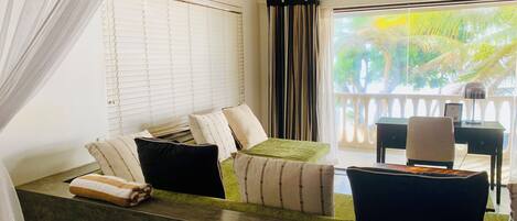 A room with a bed, a desk, and a view of the outdoors.