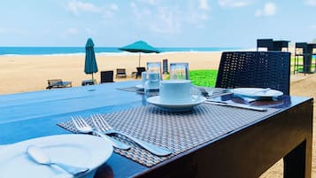 Enjoy a romantic meal for two on this beachside table, set with fine china and glassware.