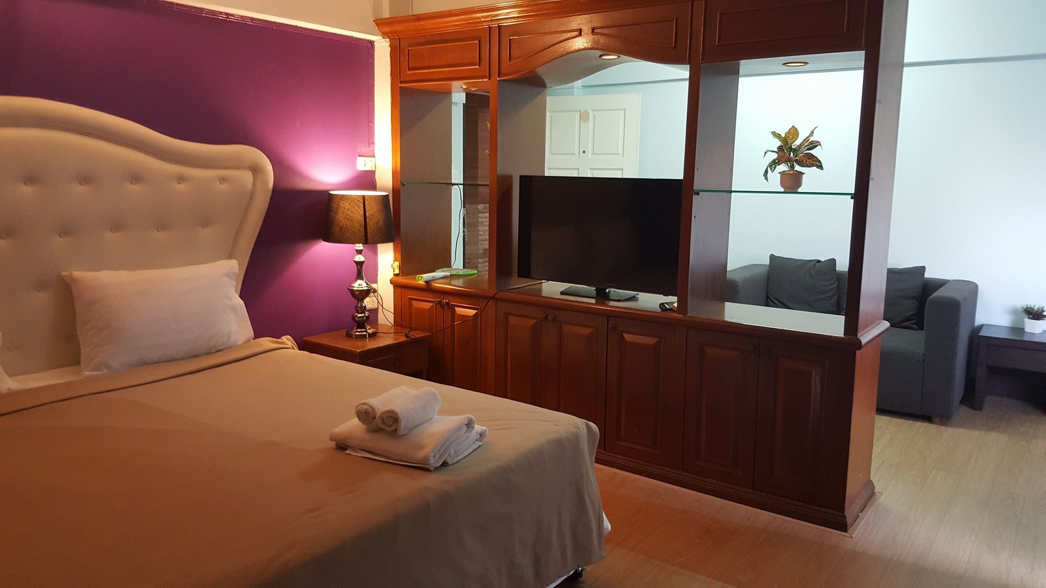 A hotel room with a bed, a TV, a desk, and a sofa.