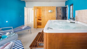 A spa area with a wooden sauna, a hot tub, and lounge seating.