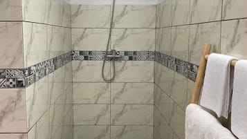 Ducha, cabezal de ducha tipo lluvia, toallas, papel higiénico