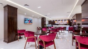 Un restaurante moderno con sillas rojas y una barra central.