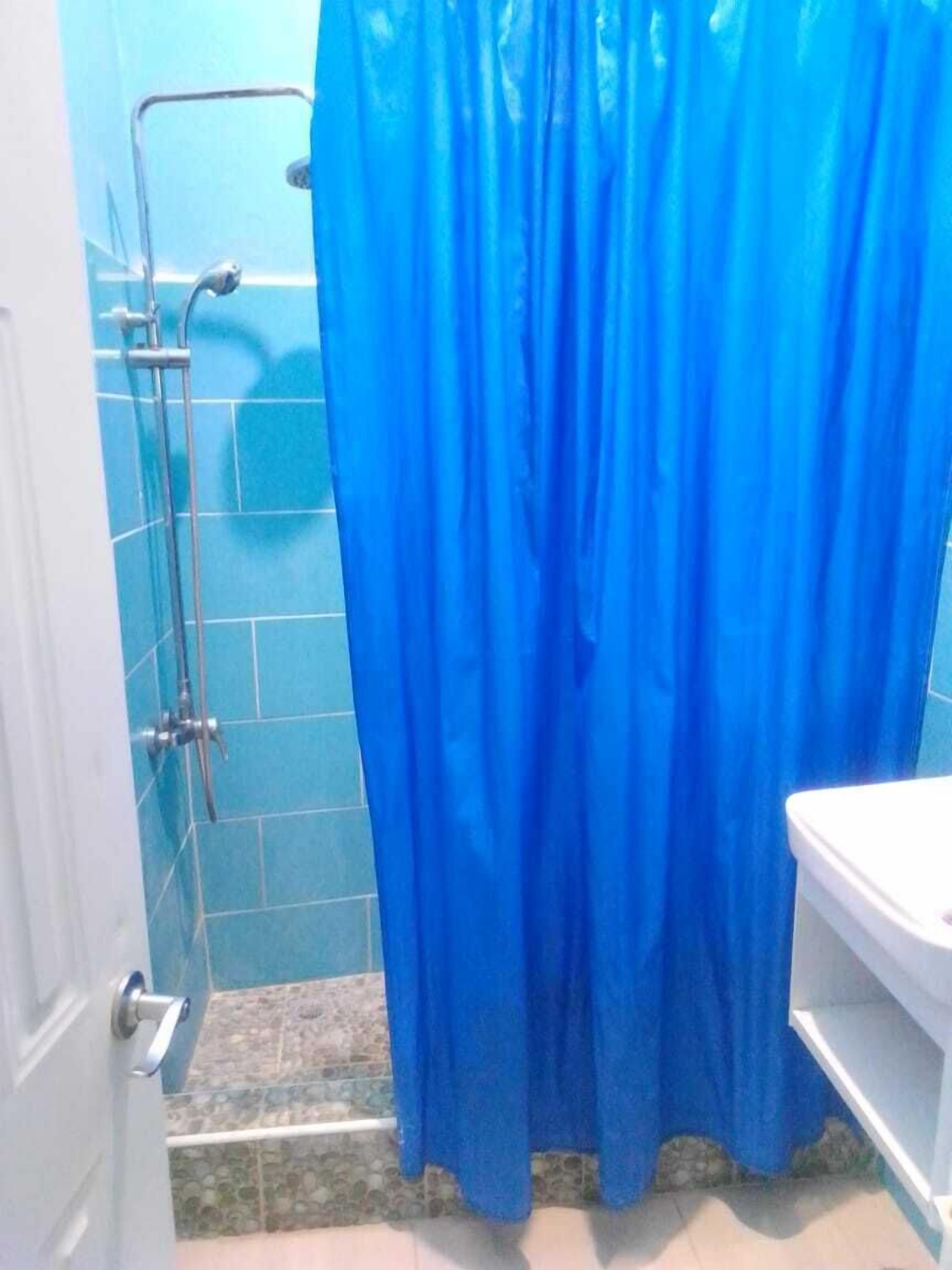Een badkamer met een douchecabine, toilet en wastafel.