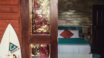 Relax in this cozy retreat with a bed and a surfboard, surrounded by lush views.