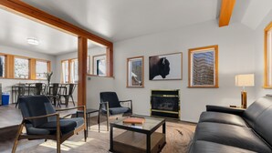Un salon moderne avec une cheminée, un canapé en cuir et deux fauteuils.