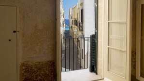 A narrow corridor with a view of a street and buildings in the distance. - Dimora storica Briganti (Gallipoli)
