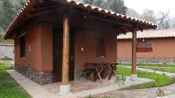 Un edificio rústico con techo de tejas, puerta de madera y una ventana pequeña.