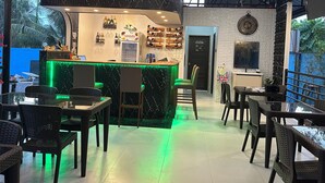 A restaurant with a bar area, seating arrangements, and a kitchen door.