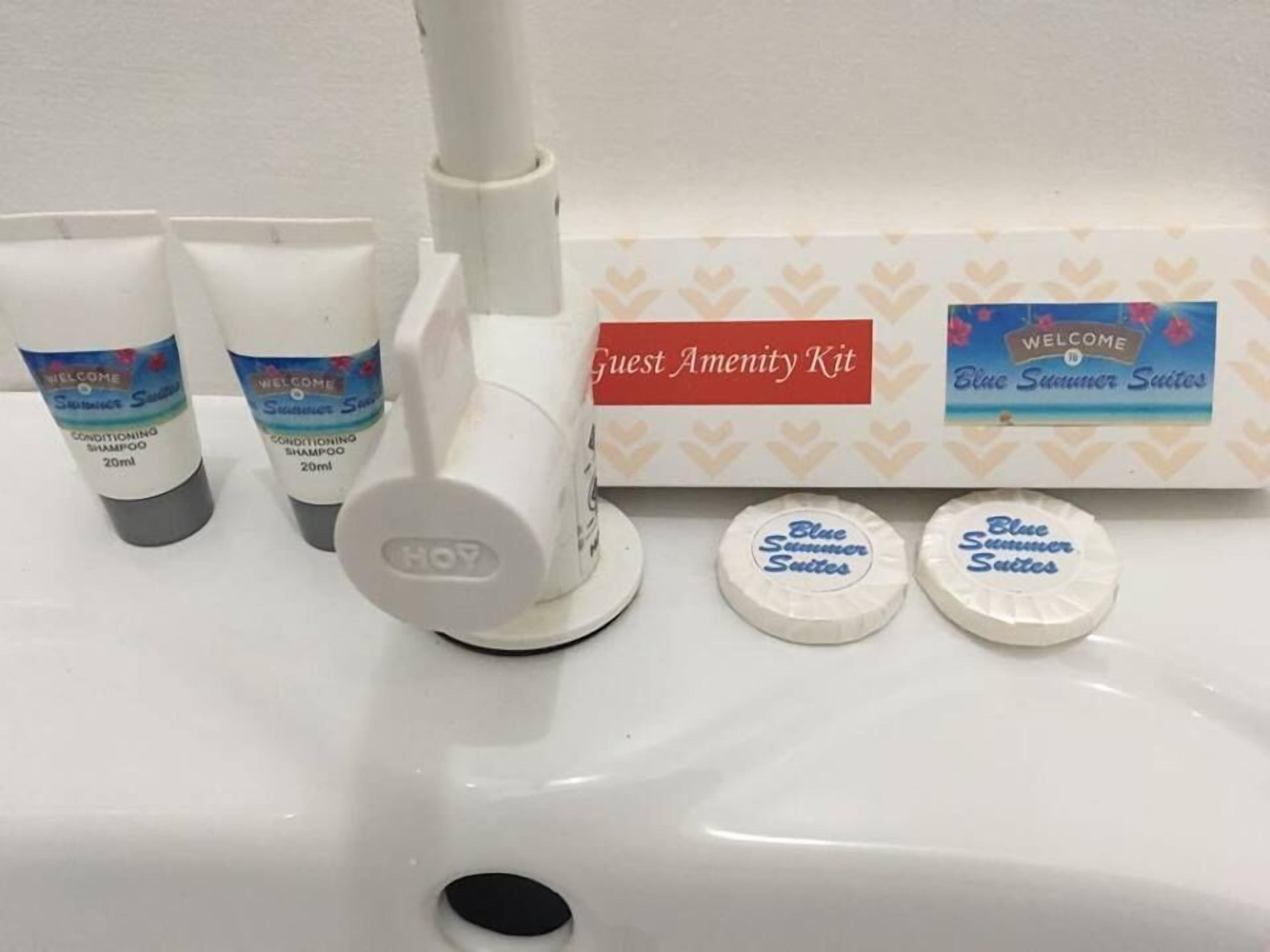 A bathroom sink with toiletries including shampoo, conditioner, and a guest amenity kit.