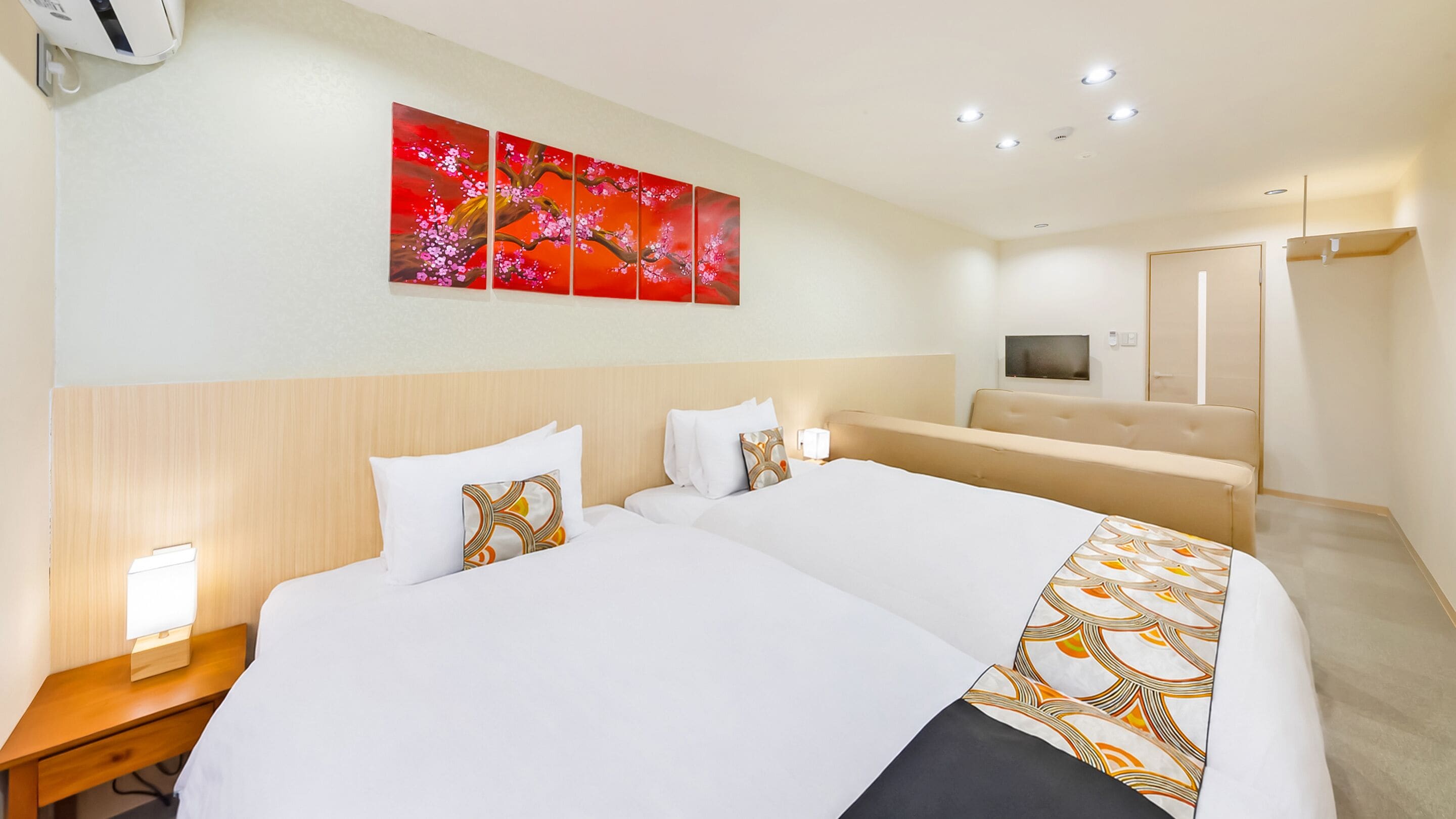 A hotel room with a large bed, bedside tables, a TV, and a painting on the wall.