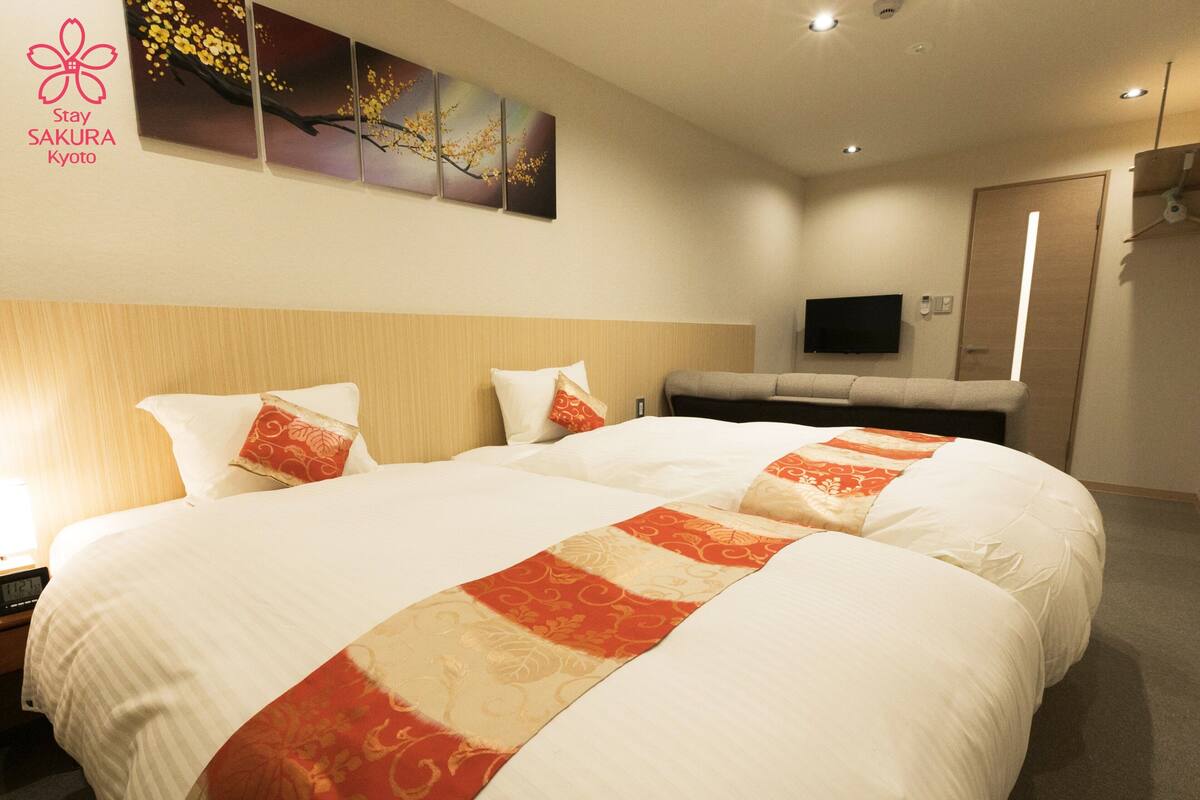 A hotel room with a large bed, a flat-screen TV, and a painting on the wall.