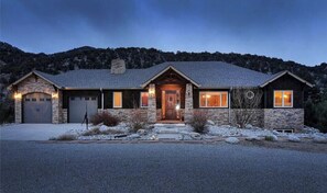 A two-story house with a stone facade, a front porch, and a garage. - Luxury Riverfront Home on 2 Acres, with Hot Tub, only minutes from downtown BV (Buena Vista)