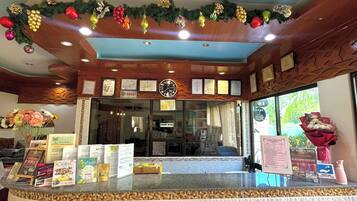 A reception area with a clock, framed certificates, and informational brochures on the counter.
