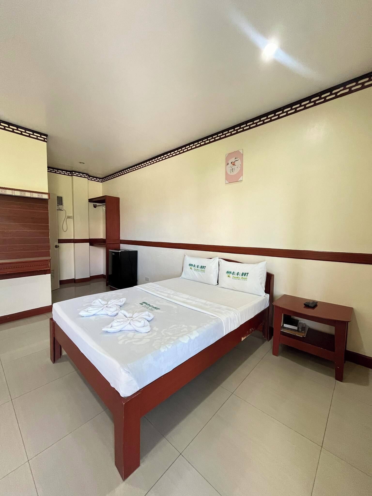 Een hotelkamer met een bed, nachtkastje en een kledingkast.