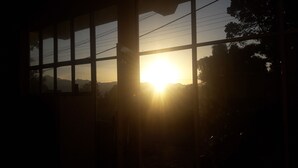 A window with a view of the sunset and mountains.