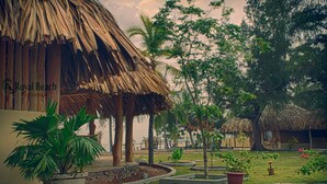 A tropical resort with thatched-roof huts, potted plants, and a well-maintained garden. - Royal Beach Arugambay (Arugam Bay)