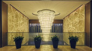 A lobby with a large chandelier, marble walls, and potted plants. - LJZ Supreme Tower Hotel(SHANGHAI New International Expo Centre) (Shanghai)