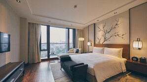 A modern hotel room with a large bed, a TV, a sofa, and a view of the city. - LJZ Supreme Tower Hotel(SHANGHAI New International Expo Centre) (Shanghai)