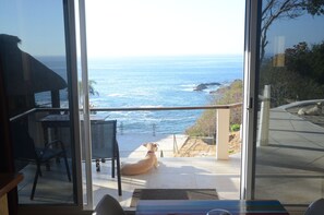 A dog sitting on a balcony overlooking the ocean. - Casablanca Guest House (Santa María Tonameca)