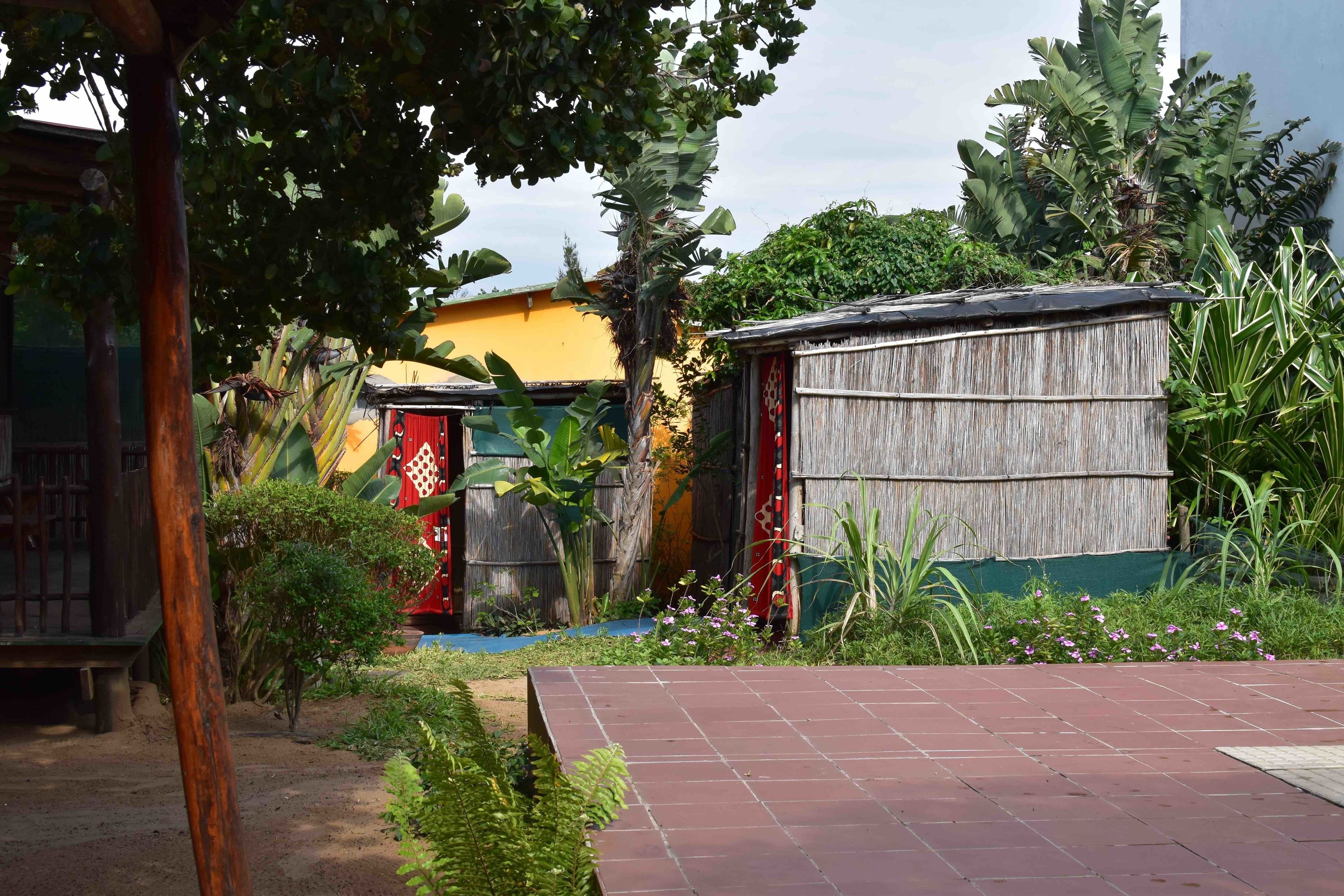 A garden with a wooden shed, a red door, and various plants.