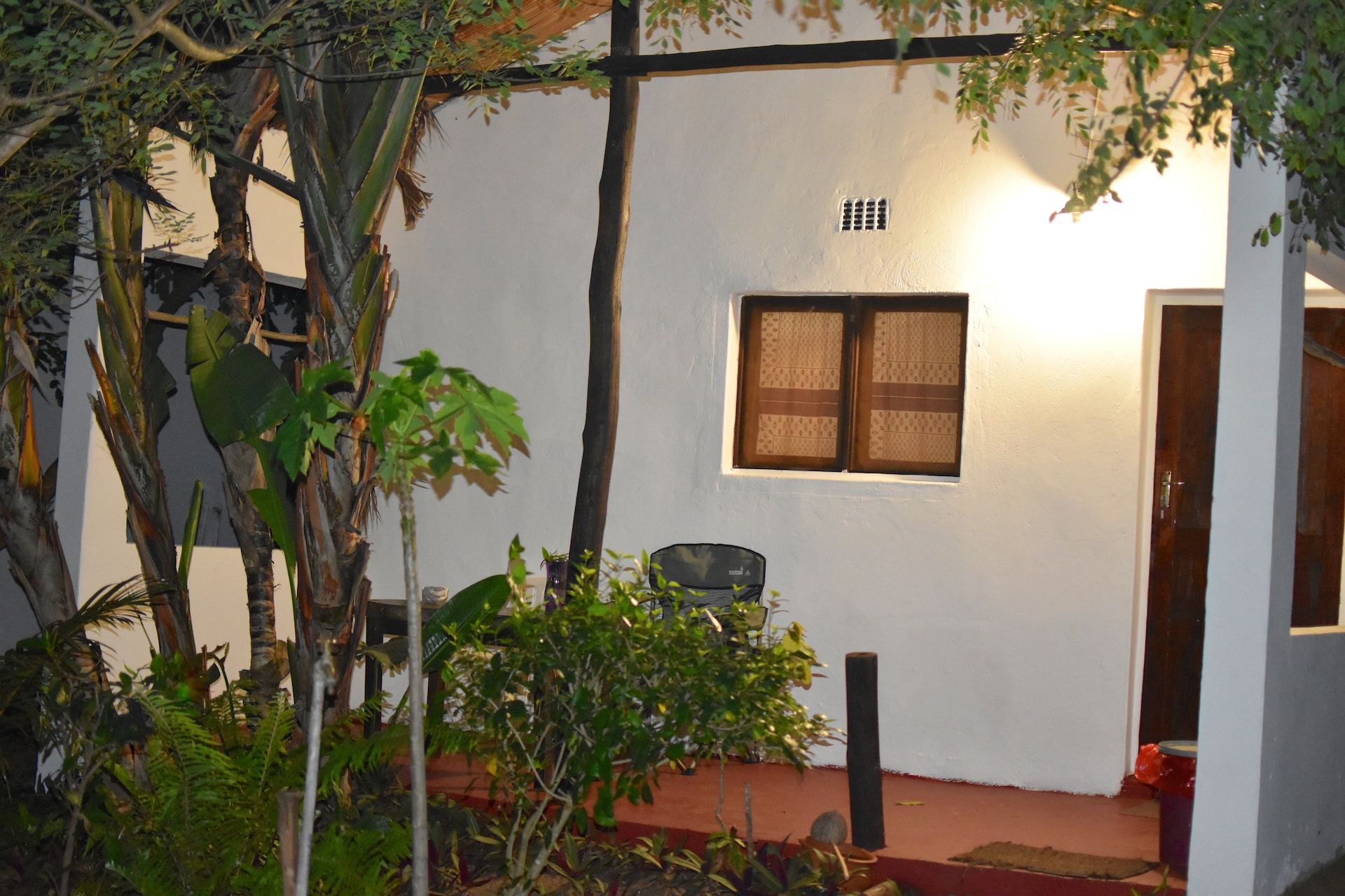 Una habitación pequeña con paredes blancas, una ventana y una puerta.