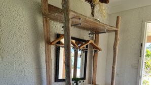A rustic wooden vanity with a mirror, a sink, and a shelf with decorative items. - Vacy Hunter Valley Lodge (Vacy)