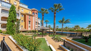 A courtyard with a pool, palm trees, and a gazebo. - Playa Grande PLUS - Punta del Moral Beach PPHG207P209 (Punta del Moral)