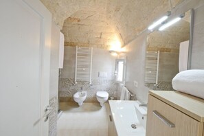 Une salle de bain équipée d’un bidet, de toilettes et d’une baignoire.