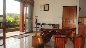 A dining area with a wooden table and chairs, a fire extinguisher, and a door with a number plate. - Tophome 9 (New Taipei City)