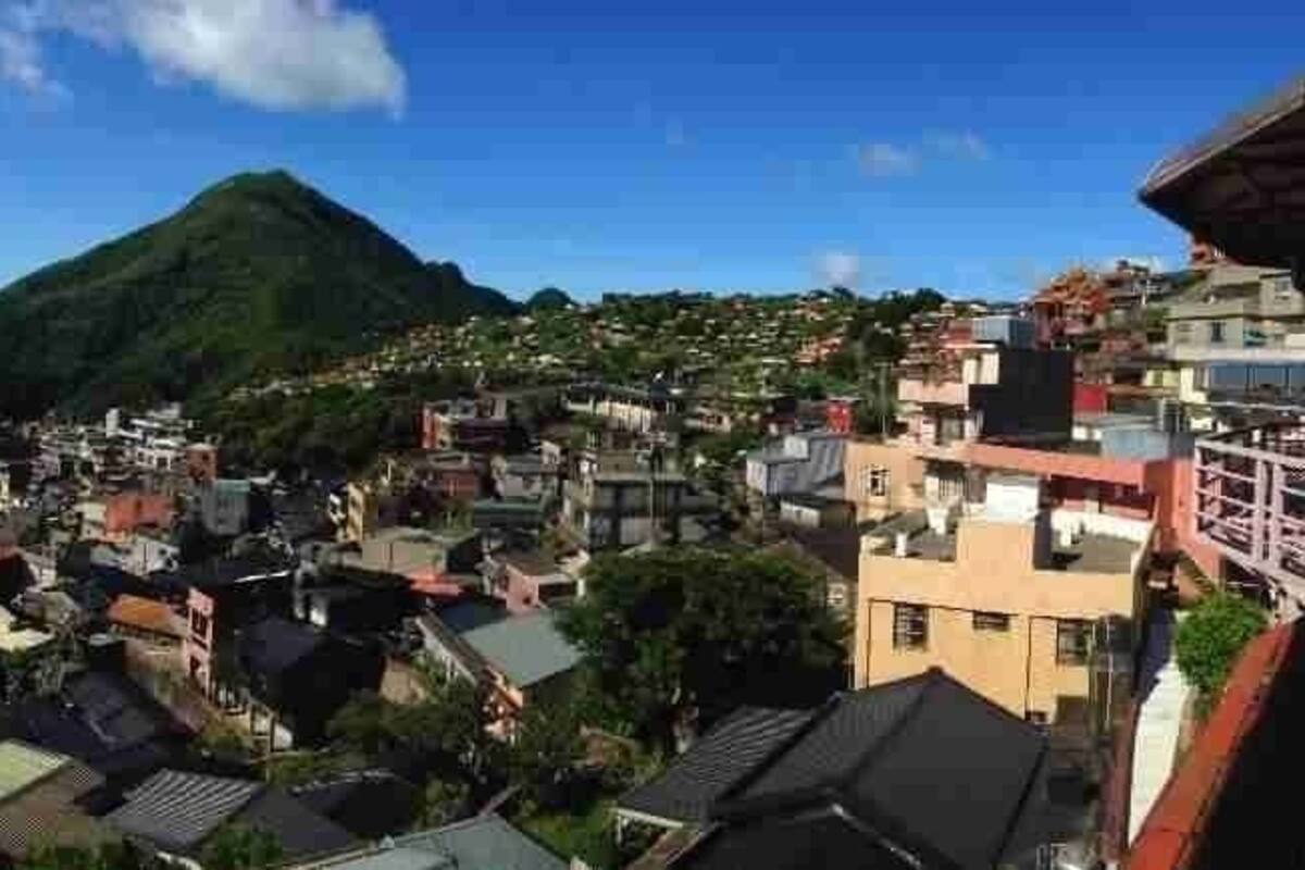 A coastal town with buildings, a mountain, and the sea.