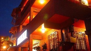 A multi-story building with a warm, orange-lit facade, a visible sign, and a gated entrance. - Tophome 9 (New Taipei City)