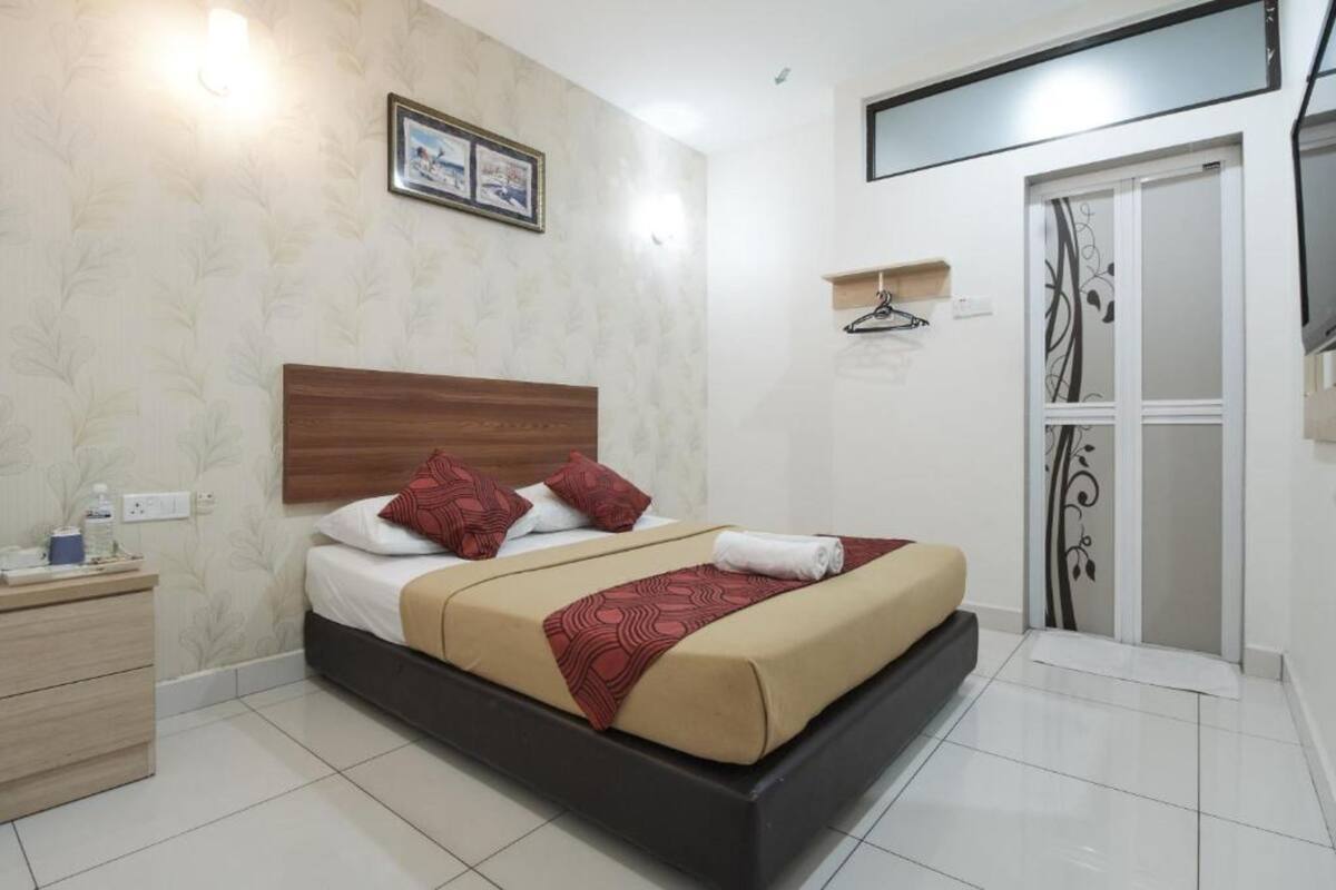 A neatly arranged bedroom with a bed, bedside table, and a wardrobe.