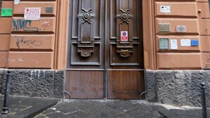 Une porte en bois à deux battants, agrémentée d’un portail en métal, une enseigne indiquant un cabinet dentaire et une plaque numérotée sur le bâtiment.