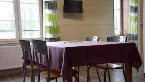 Ein Essbereich mit einem Tisch, der mit einer violetten Tischdecke bedeckt ist, umgeben von vier Stühlen.