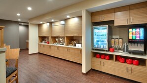 Un área de cocina moderna con armarios de madera, un refrigerador y una cafetera.