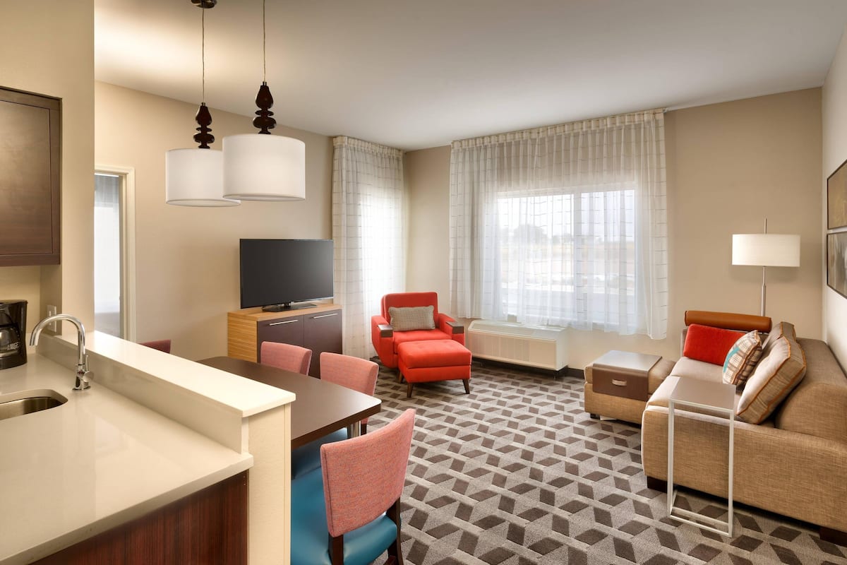 Une chambre d’hôtel équipée d’une kitchenette, d’un coin repas, d’un canapé et d’une télévision.