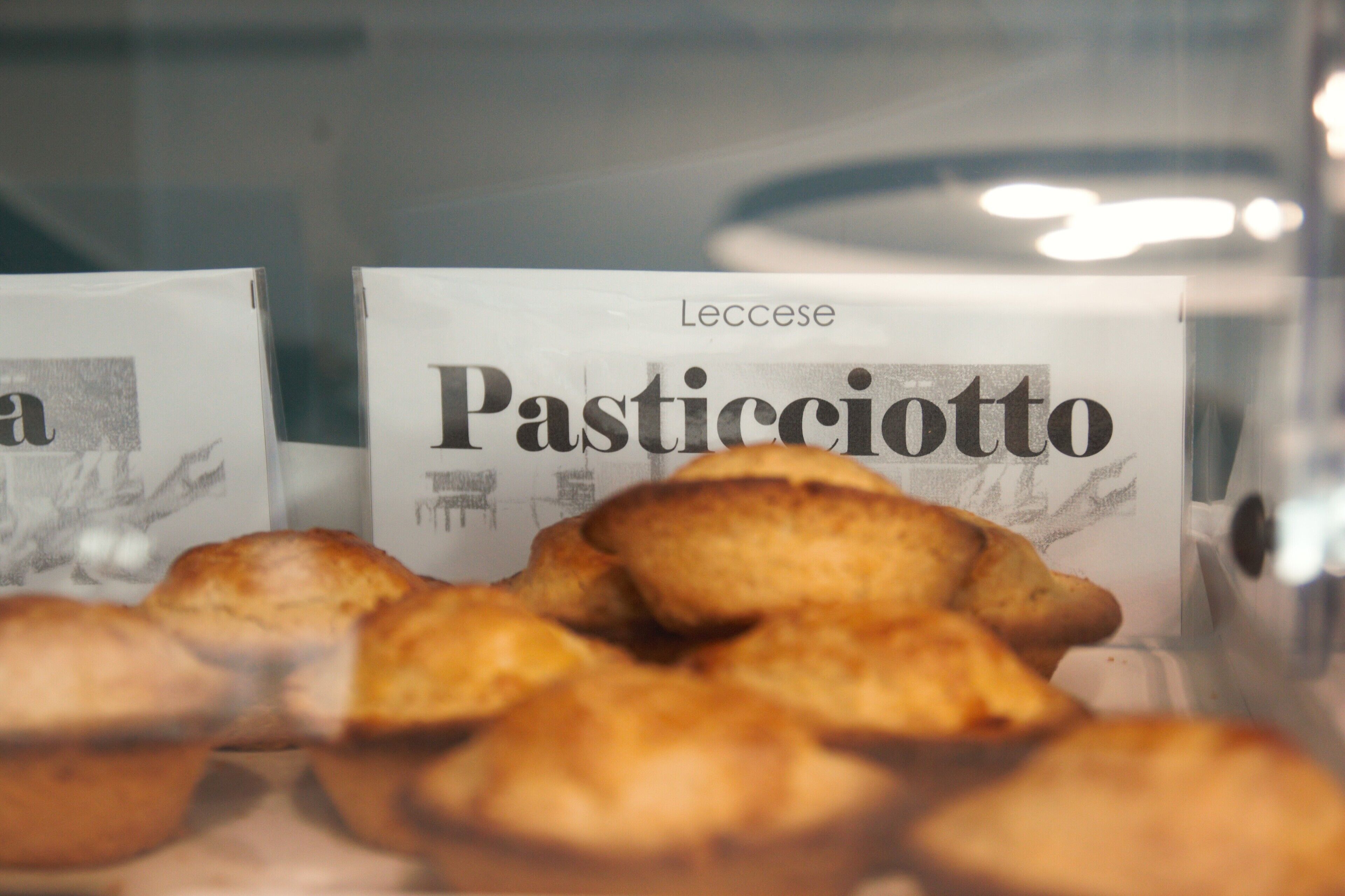 Une vitrine remplie de pâtisseries, chacune étant étiquetée « Pasticciotto de Lecce ».