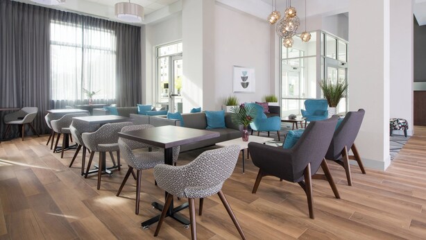 A modern dining area with a mix of seating options, including tables and chairs, and a large window providing natural light. - Fairfield by Marriott Inn & Suites Dayton Downtown (Dayton)
