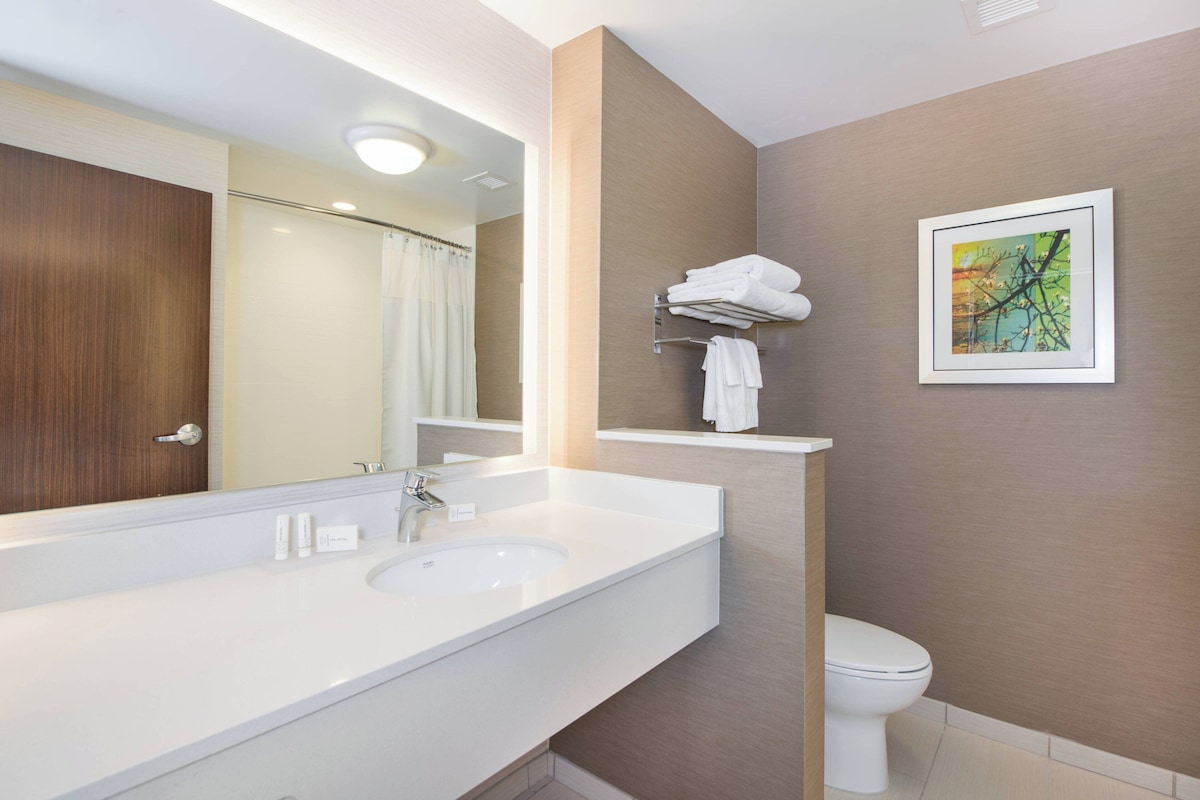 Een moderne badkamer met een groot wastafel, toilet en douche.